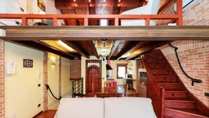 A loft-style room with a high ceiling, exposed wooden beams, a staircase, and a dining area with a table and chairs. - The SpaceDreaming of a stay filled with history, charm, and comfort just a few kilometers from Venice and the Venetian Villas?This beautiful two-story independent house, with its mix of rustic and modern style, is the perfect retreat for those seeking bo (Mira)