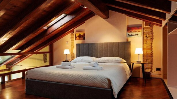 A bedroom with a large bed, wooden beams, stone walls, and a view through a skylight. - The SpaceDreaming of a stay filled with history, charm, and comfort just a few kilometers from Venice and the Venetian Villas?This beautiful two-story independent house, with its mix of rustic and modern style, is the perfect retreat for those seeking bo (Mira)