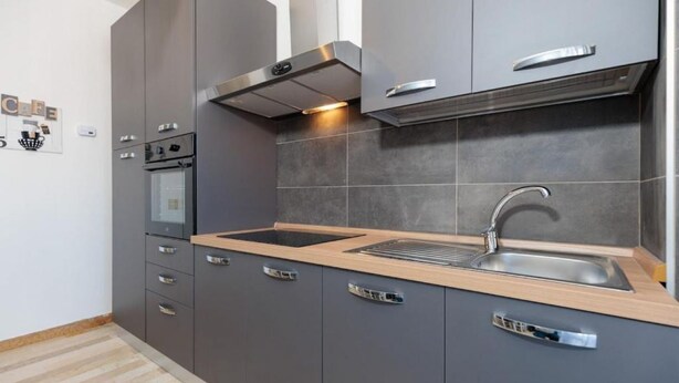 A modern kitchen with grey cabinets, a wooden countertop, a stainless steel sink, and a built-in oven. - The SpaceLooking for a comfortable, stylish, and strategically located stay to explore Venice and beyond? This newly renovated home in Mestre is the ideal solution for families, small groups, and travelers seeking both comfort and convenience.Just steps  (Venezia)