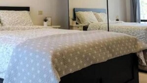 A bedroom with a black headboard, a white bedside table, and a bed with a floral-patterned bedspread. - The SpaceSpacious, comfortable, and bright apartment located near Jesolo beach and the famous Caribe Bay water park.The house enjoys a super strategic position, allowing you to make the most of everything Jesolo Lido has to offer.The apartment can host u (Lido di Jesolo)