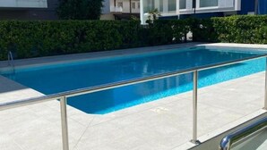 A swimming pool with a metal railing, surrounded by a hedge and buildings in the background. - The SpaceSpacious, comfortable, and bright apartment located near Jesolo beach and the famous Caribe Bay water park.The house enjoys a super strategic position, allowing you to make the most of everything Jesolo Lido has to offer.The apartment can host u (Lido di Jesolo)