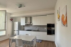 A modern kitchen with white cabinets, a dining table, and a large window. - The Space✨ Brand New, Modern & Super Comfortable Home at the Gates of Venice – All the Best, Without the Stress ✨Welcome to your brand-new “home away from home”!This property has been completely renovated from top to bottom: from shiny new floo (Venice)
