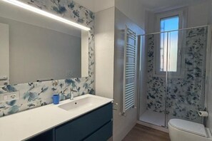 A bathroom with a white sink, blue cabinet, and a shower with a glass door. - The Space✨ Brand New, Modern & Super Comfortable Home at the Gates of Venice – All the Best, Without the Stress ✨Welcome to your brand-new “home away from home”!This property has been completely renovated from top to bottom: from shiny new floo (Venice)