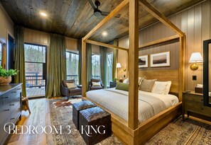 Ein Schlafzimmer mit einem Himmelsbett, Holzbalkendecke und großen Fenstern.