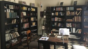 A room with two large bookshelves filled with books, a wooden desk with papers, and a chair. - Casa palaciega Doña Leocadia (Viana)