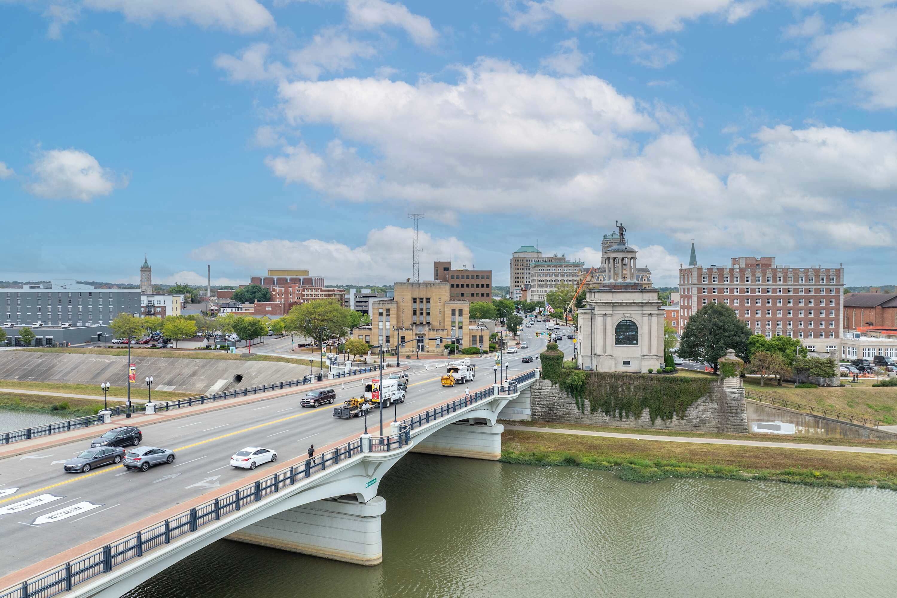 A bridge over a river with a cityscape in the background.