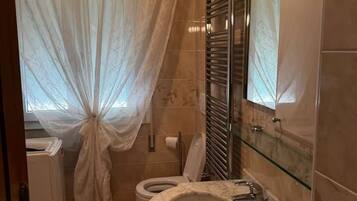 Een badkamer met toilet, douchecabine en wastafel.