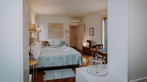 Un dormitorio con una cama, mesita de noche, lámpara y un mapa en la pared.