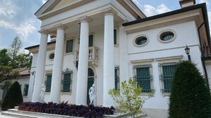 Een klassiek gebouw met kolommen, een portico en beelden.