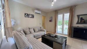A living room with a sofa, a coffee table, and a TV. - Kika Residence - 2 Bedroom House With Barbeque (Kefalonia)