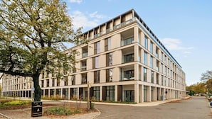 Um edifício de vários andares com design arquitetônico moderno, com grandes janelas e varandas.