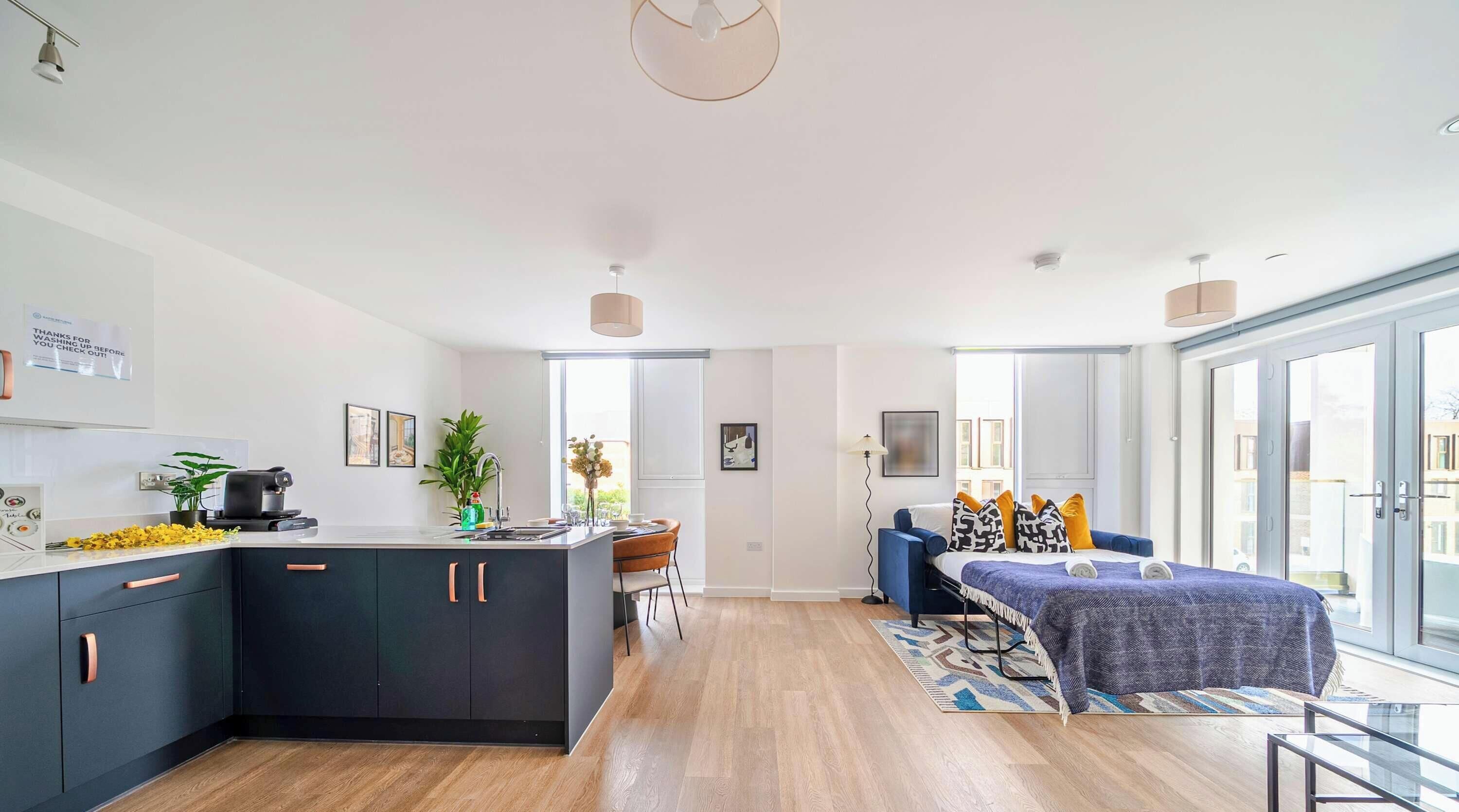 Un apartamento moderno con cocina, comedor y un dormitorio con ventana grande.