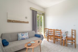 Ein Wohnzimmer mit einer Couch, einem Couchtisch und einem Essbereich mit Stühlen und einem Tisch.