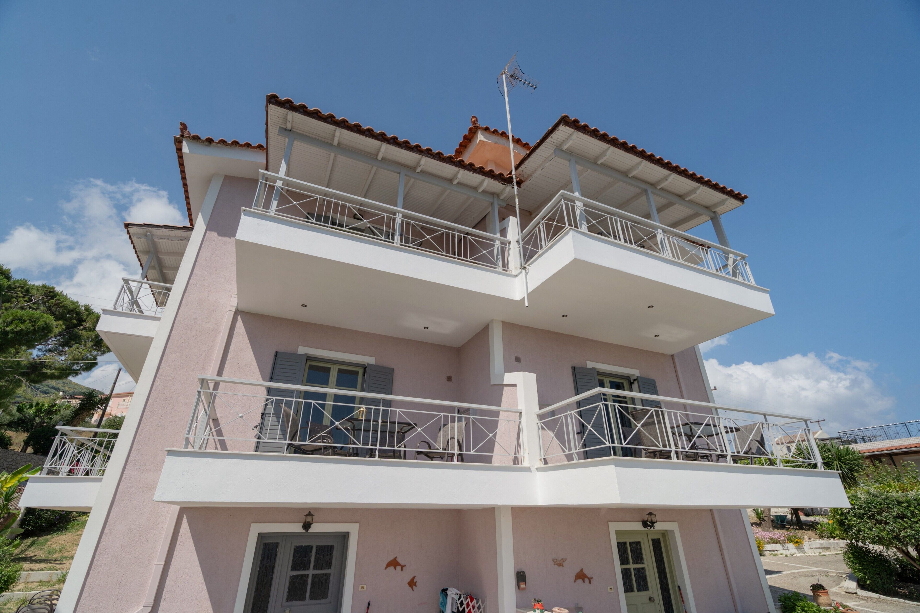 Un edificio de varios pisos con balcones, techo plano y cielo despejado.