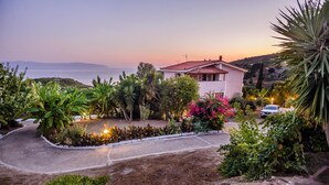 Una casa con jardín, entrada para coches y vistas al mar.