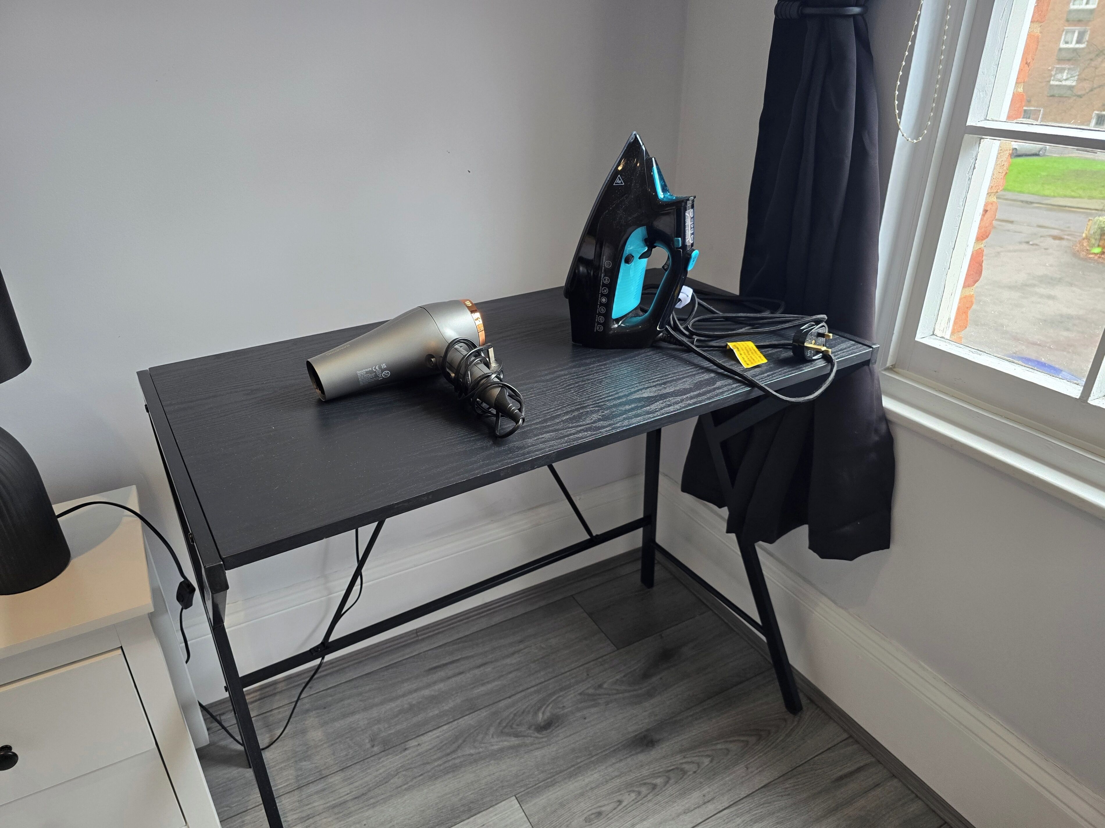 Une chambre équipée d’un bureau, d’un sèche-cheveux et d’une multiprise.