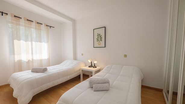 A hotel room with two beds, a small table with a lamp, and a framed picture on the wall. - Corporate or Formative Lodging 4 rooms / 6 beds (Coslada)