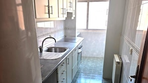 A narrow kitchen with a sink, cabinets, and a window. - Corporate or Formative Lodging 4 rooms / 6 beds (Coslada)