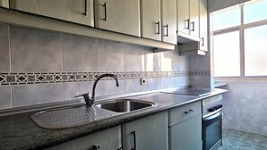 A kitchen with light-colored cabinets, a stainless steel sink, and a tiled backsplash. - Corporate or Formative Lodging 4 rooms / 6 beds (Coslada)