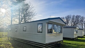 Ein Wohnmobil mit einer Veranda, einem kleinen Fenster und einer Tür.