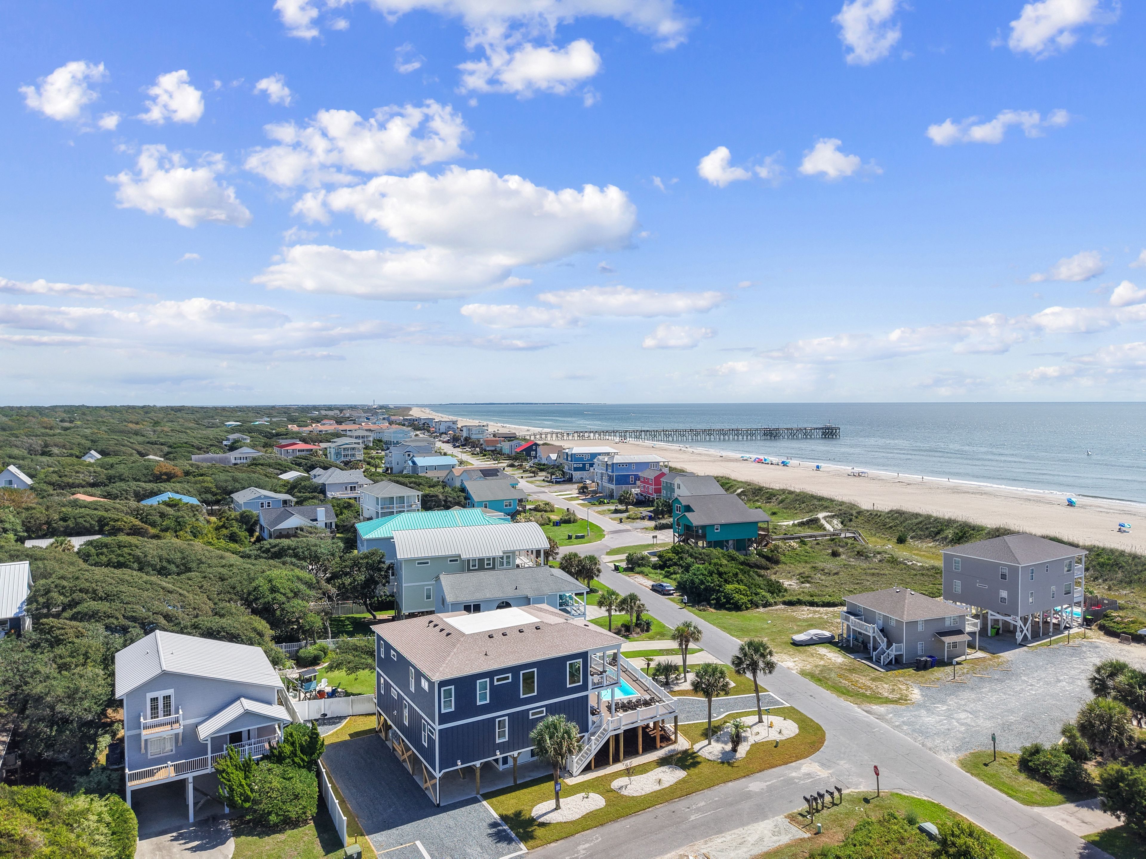 Une zone résidentielle côtière comprenant des maisons, une plage et une jetée.