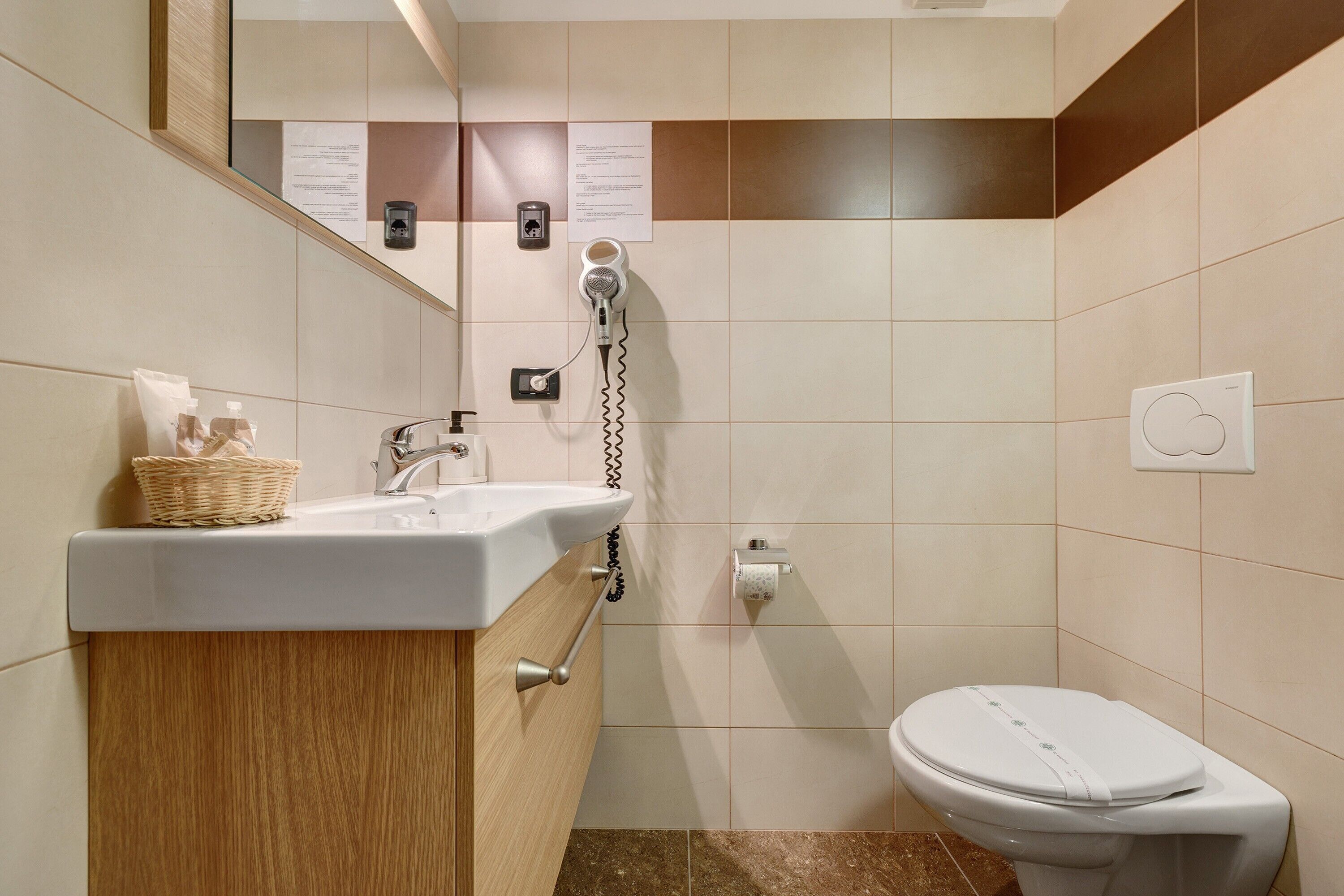 Ein Badezimmer mit Waschbecken, Spiegel, Handtuchhalter und Toilette.