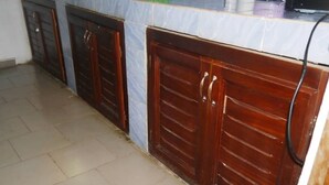 Una cocina con armarios de madera y piso de baldosas.