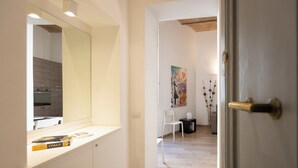 A modern kitchen with a white countertop and a large mirror.