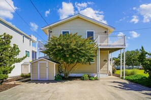 A two-story house with a balcony, a small shed, and a tree in the front yard. - Coastal Retreat in South Bethany (South Bethany)