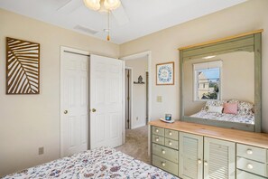 A bedroom with a bed, dresser, mirror, and two doors. - Coastal Retreat in South Bethany (South Bethany)