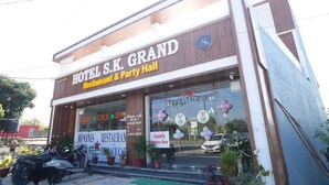 Een hotel met een bord waarop staat: HOTEL S.K. GRAND Restaurant & Party Hall.