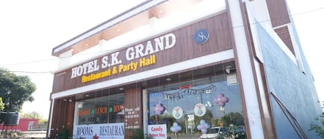 A hotel with a sign reading "HOTEL S.K. GRAND Restaurant & Party Hall".