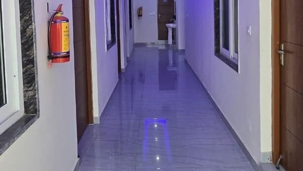 Een gang met een marmeren vloer en blauw LED-verlichting in het plafond.