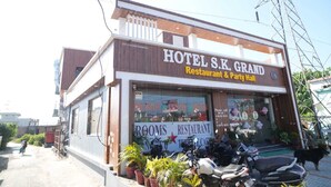 Een gebouw met twee verdiepingen, met een bord waarop staat: HOTEL S.K. GRAND Restaurant & Party Hall.