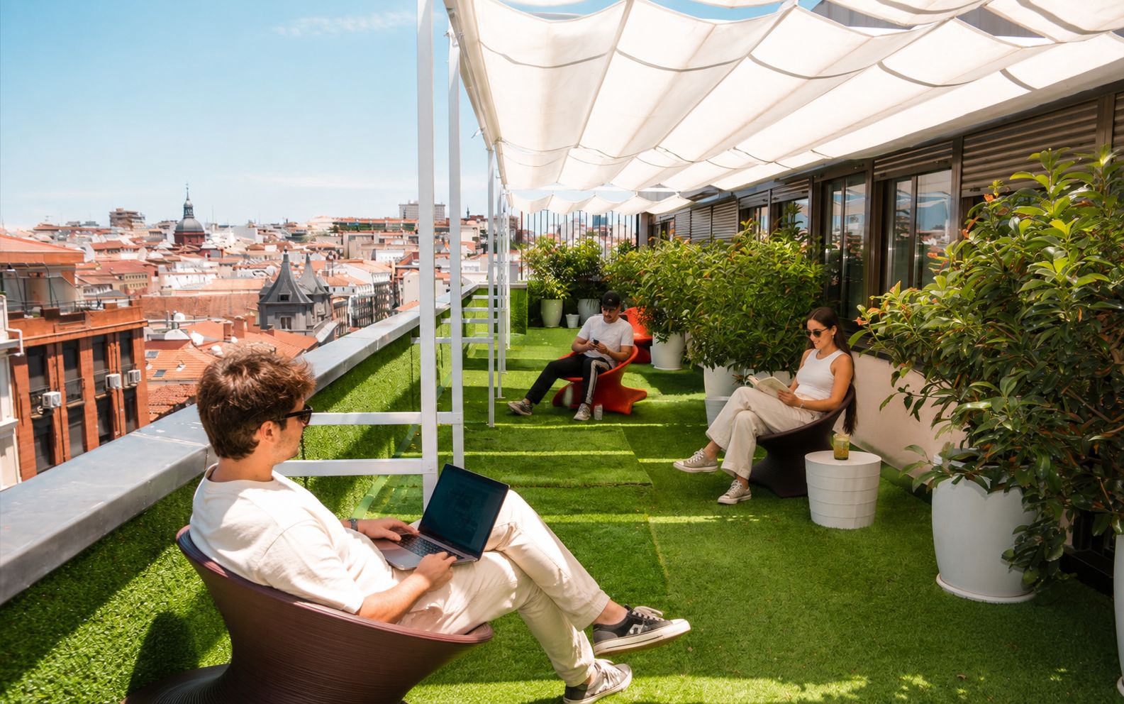 Una terraza en la azotea con césped artificial, zonas de estar y plantas en macetas.
