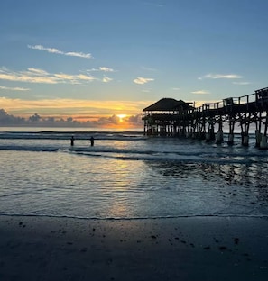 A pier extending into calm waters with a sunset in the background. - Island Vacation Home - Minutes from the Beach ! (Merritt Island)