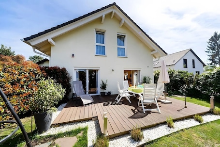 A two-story house with a deck, outdoor seating, and a garden.. Lake Constance Holiday Home with Private Terrace, Garden and Wi-Fi