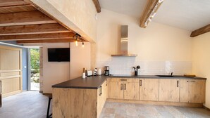 Une cuisine avec des meubles en bois, un plan de travail noir et une hotte en acier inoxydable.