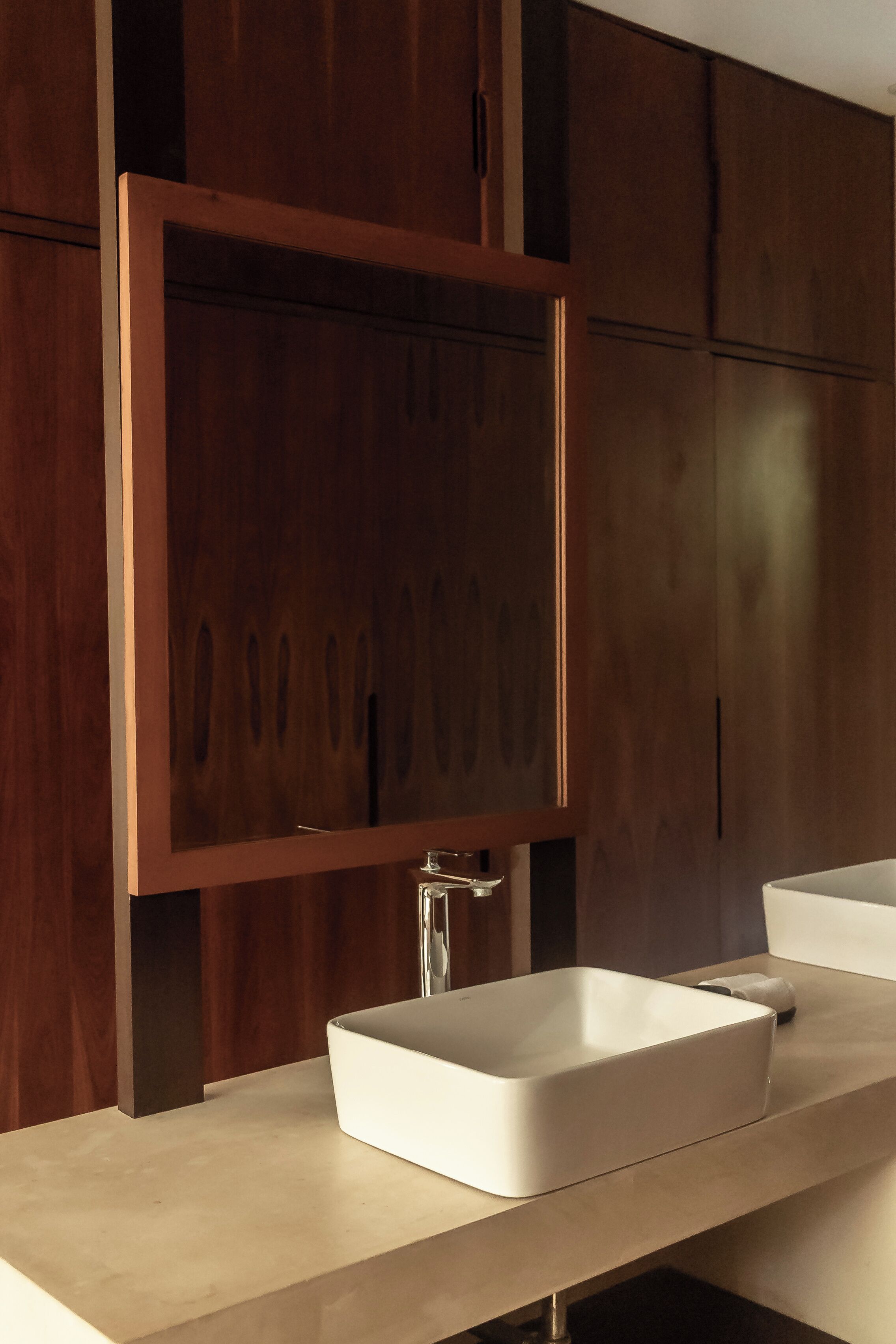 Une salle de bain moderne avec un grand miroir, un lavabo rectangulaire et des meubles en bois.