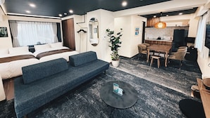A modern hotel room with a bed, a sofa, a dining table, and a kitchen area. - Plan A Tennozu Isle (Tokyo)