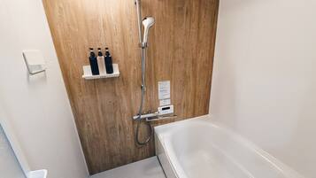 A modern bathroom with a wooden wall, a white bathtub, and a shower area.