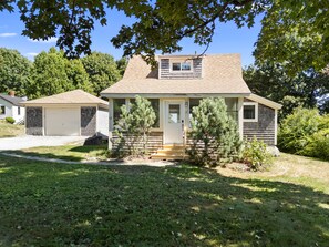 A two-story house with a front porch, a garage, and a small detached garage. - Lupine Cottage | Walk to Downtown Rockland Harbor (Owls Head)