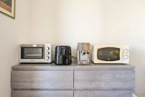 Un plan de travail de cuisine avec un four à micro-ondes, une machine à café et un four grille-pain.