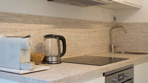 Eine Küche mit Kaffeemaschine, Wasserkocher und Spüle.