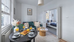 Un salon moderne avec un canapé, une table basse et un coin repas pour le petit-déjeuner.