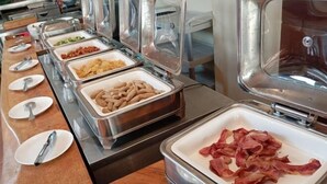 A buffet setup with various food items in clear containers, including bacon and other meats. - Kuta Town Houses (Bali)
