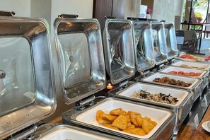 A buffet line with various food items in metal containers. - Kuta Town Houses (Bali)