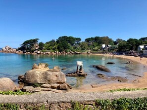 A coastal beach with clear water, large rocks, and a few people. - Ty Kerzont: A charming gîte, an oasis of nature and tranquility, near Perros-Guirec, (COATREVEN)