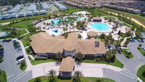 Et resort med flere swimmingpools, en central bygning og en parkeringsplads.