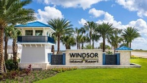 Une enseigne indiquant le complexe hôtelier Windsor Island Resort, avec un bâtiment doté d’un toit bleu et d’une façade blanche.